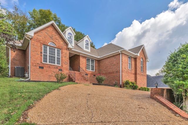 view of property with central air condition unit and a front lawn