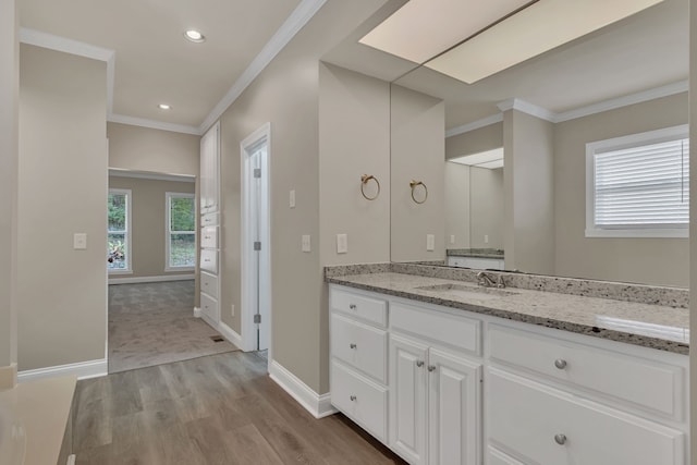 bathroom with hardwood / wood-style floors, vanity, and ornamental molding