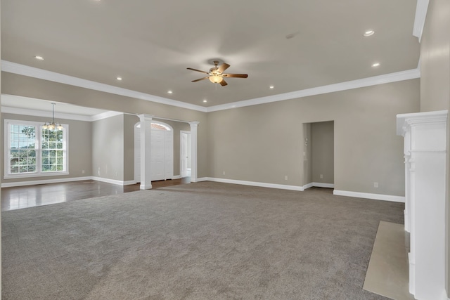 unfurnished living room featuring ornamental molding, decorative columns, and dark carpet