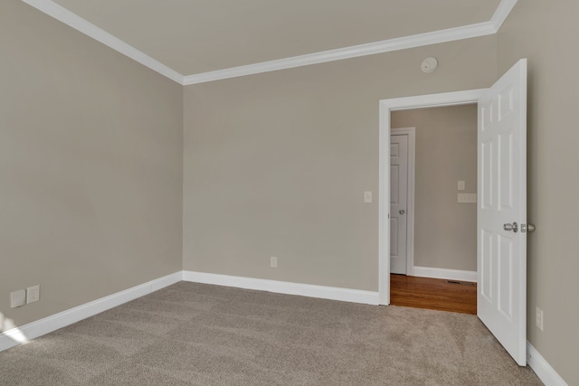 unfurnished room featuring light colored carpet and crown molding