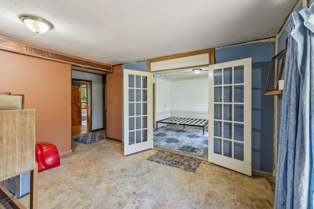 interior space with french doors and a textured ceiling