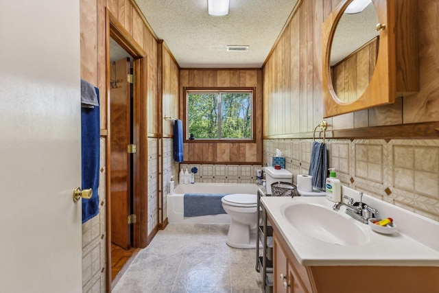 full bath featuring visible vents, vanity, toilet, a textured ceiling, and a bath