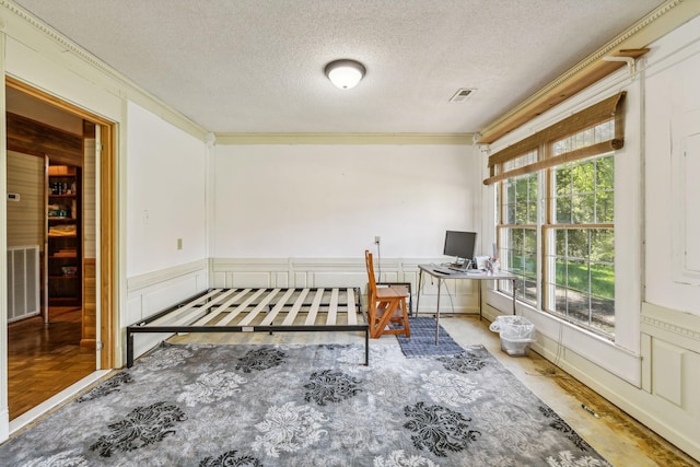 bedroom featuring crown molding, a textured ceiling, and visible vents