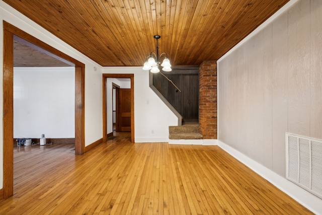 interior space featuring a notable chandelier, wood walls, wooden ceiling, and light hardwood / wood-style flooring