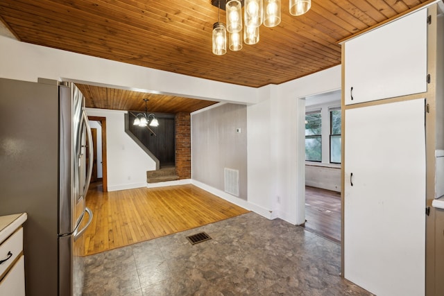 kitchen featuring decorative light fixtures, white cabinetry, stainless steel refrigerator, dark hardwood / wood-style floors, and wooden ceiling