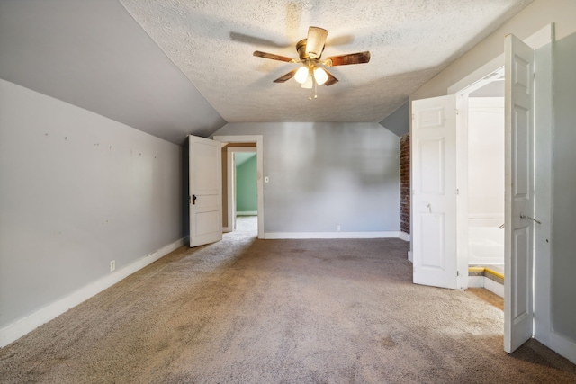 bonus room with lofted ceiling, ceiling fan, carpet, and a textured ceiling