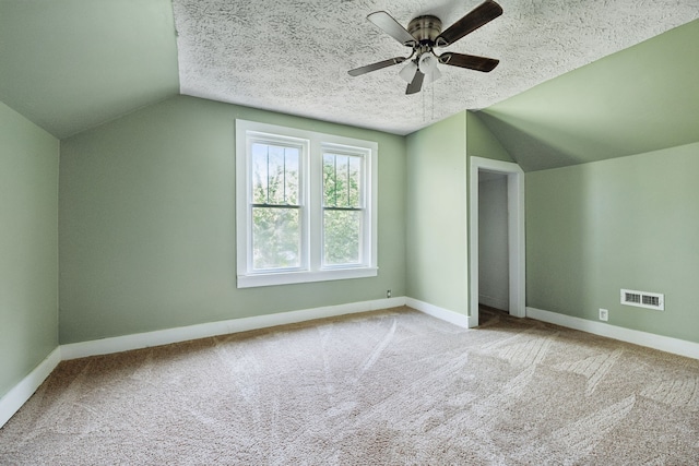 bonus room with light carpet, a textured ceiling, and vaulted ceiling