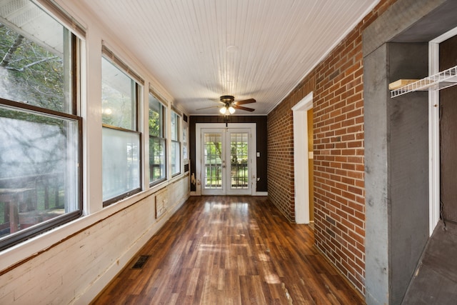 unfurnished sunroom featuring ceiling fan and french doors