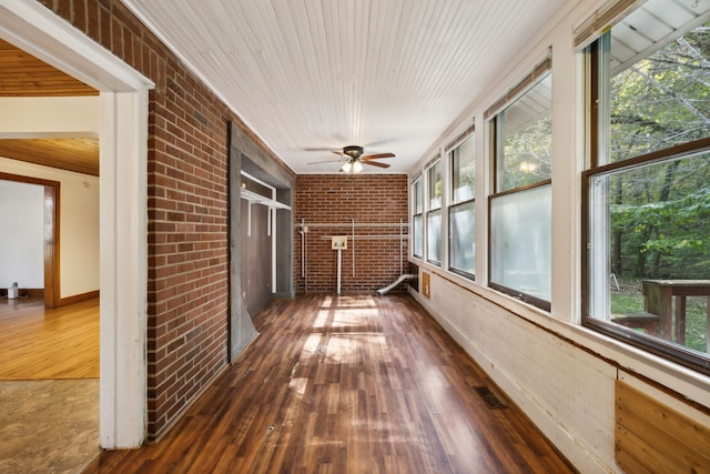 unfurnished sunroom with wooden ceiling, a wealth of natural light, and ceiling fan