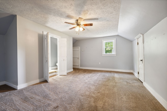 bonus room with light carpet, ceiling fan, vaulted ceiling, and a textured ceiling