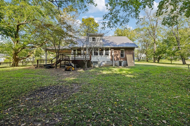 rear view of property featuring a lawn and a deck