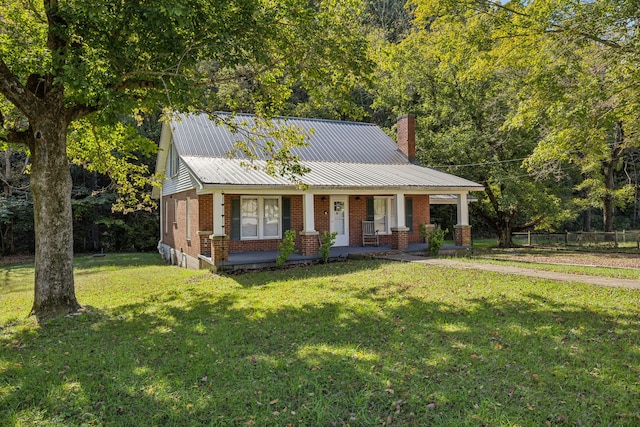 view of front of house with covered porch and a front yard