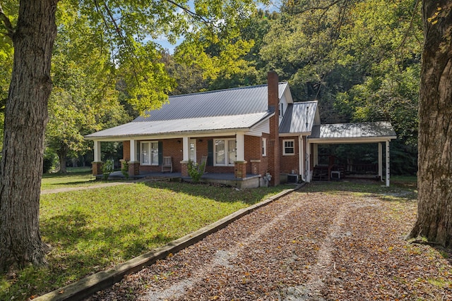 view of front of house with a front yard, central AC, and covered porch