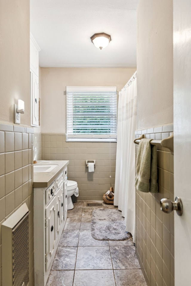 bathroom featuring vanity, tile walls, toilet, and a shower with curtain