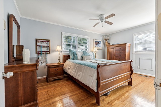 bedroom with ceiling fan, ornamental molding, hardwood / wood-style floors, and multiple windows