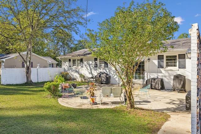 back of house with a yard and a patio