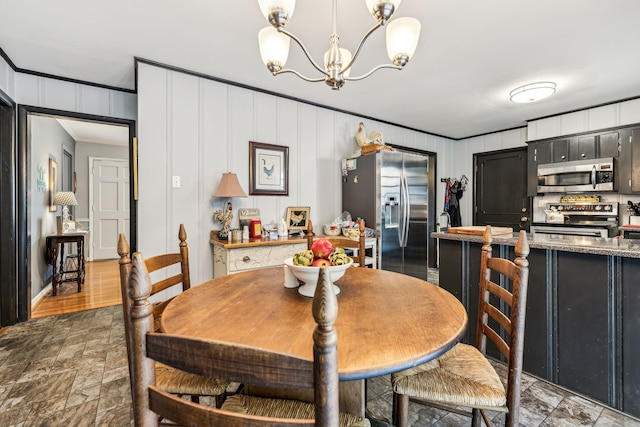 dining area with wood walls, crown molding, and a chandelier