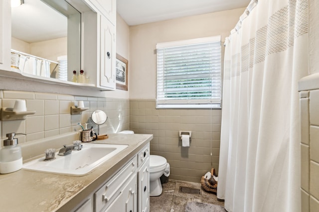 bathroom featuring vanity, tile walls, toilet, and tile patterned floors