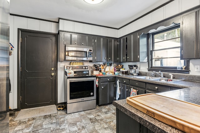 kitchen featuring appliances with stainless steel finishes, crown molding, and sink