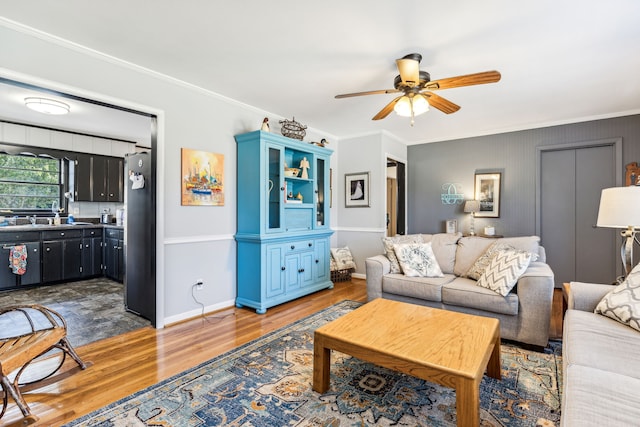 living room featuring ornamental molding, hardwood / wood-style flooring, and ceiling fan