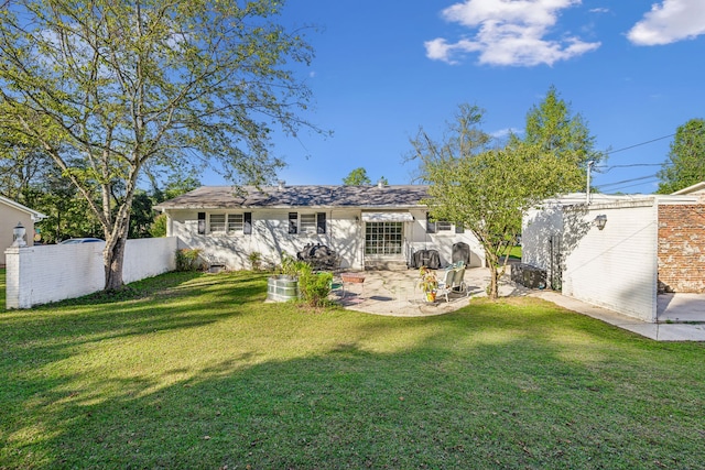 rear view of property featuring a patio and a lawn