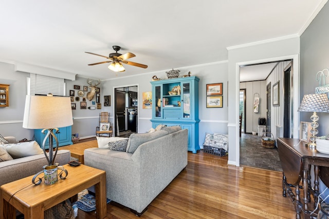 living room with crown molding, hardwood / wood-style floors, and ceiling fan