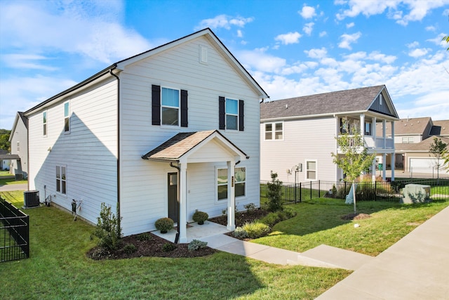 view of front property with a front lawn, central AC, and a balcony