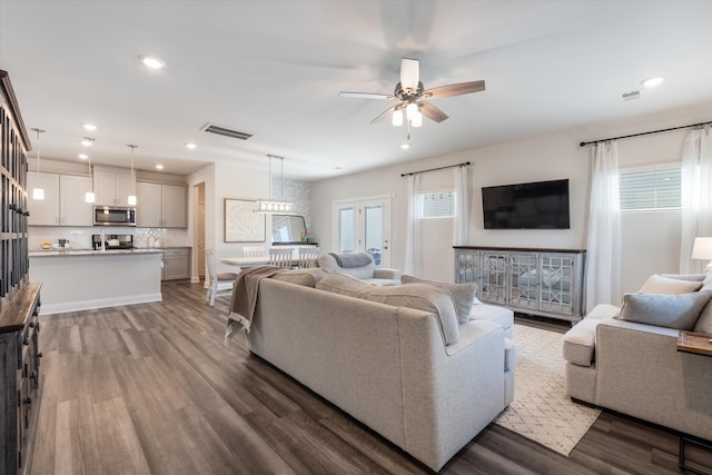 living room featuring ceiling fan, hardwood / wood-style floors, and a wealth of natural light