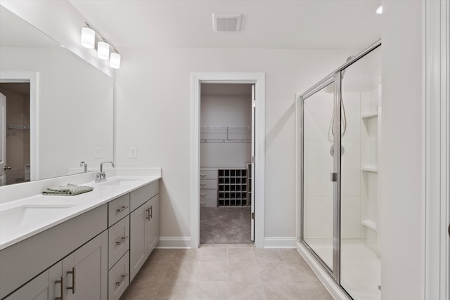 bathroom featuring tile patterned floors, a shower with door, and vanity