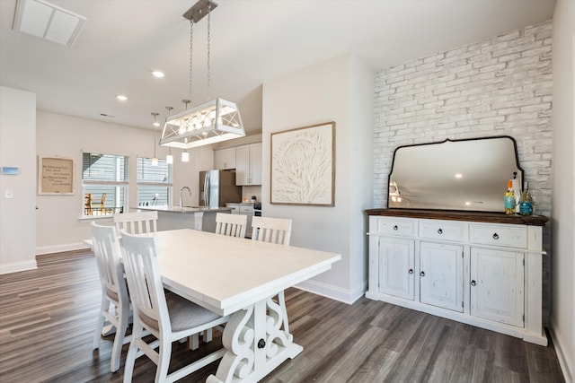 dining space featuring sink and dark hardwood / wood-style flooring