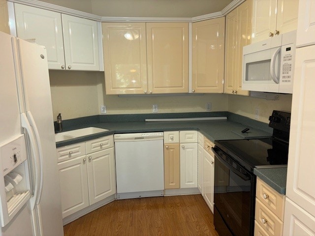 kitchen with dark wood-type flooring, white appliances, sink, and white cabinetry