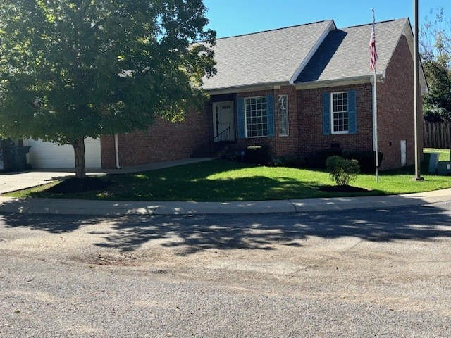 view of front of house featuring a garage and a front lawn