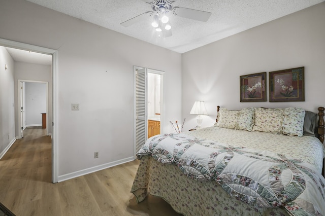 bedroom with ceiling fan, a textured ceiling, connected bathroom, and wood-type flooring