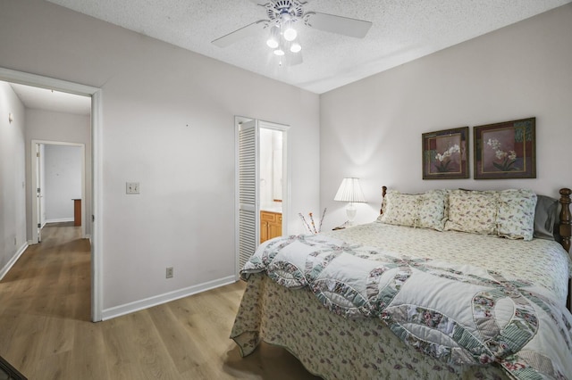 455 Bluff View Dr, Spencer, TN 38585 - bedroom with wood finished floors, baseboards, connected bathroom, a ceiling fan, and a textured ceiling