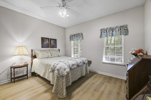 bedroom with wood-type flooring, a textured ceiling, and ceiling fan