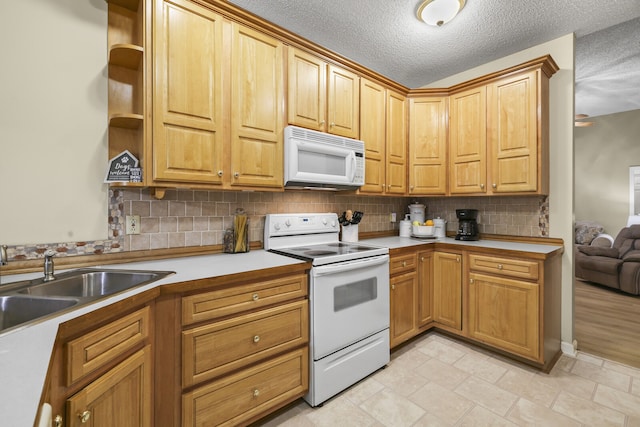 kitchen featuring white appliances, backsplash, sink, and a textured ceiling