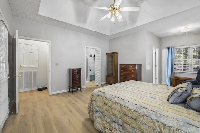 bedroom with ceiling fan, light hardwood / wood-style floors, and a textured ceiling