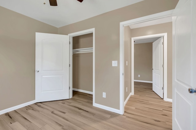 unfurnished bedroom with ceiling fan, light wood-type flooring, and a closet