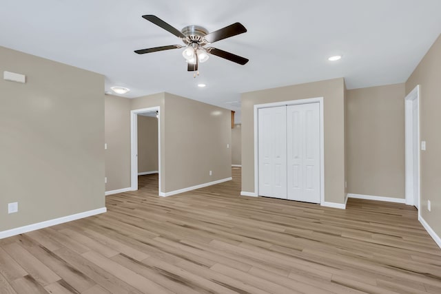 unfurnished bedroom featuring a closet, light hardwood / wood-style flooring, and ceiling fan