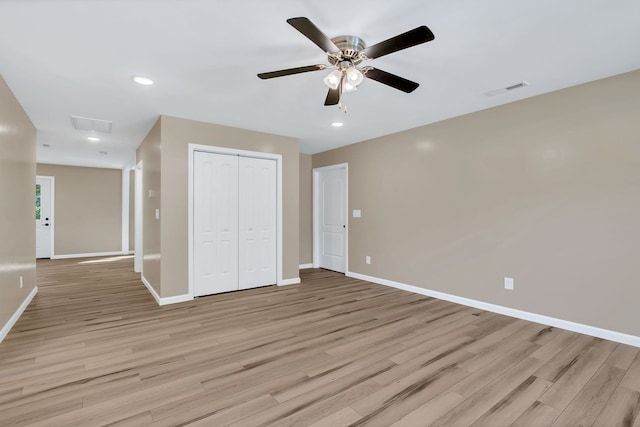 unfurnished bedroom featuring ceiling fan, a closet, and light hardwood / wood-style flooring