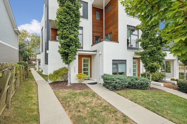 property entrance featuring a balcony and a yard