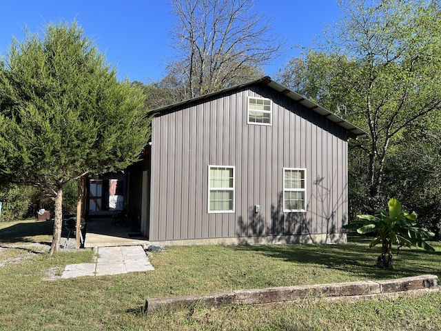 view of side of home with an outdoor structure and a lawn