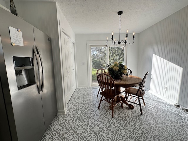 dining space featuring a notable chandelier and a textured ceiling