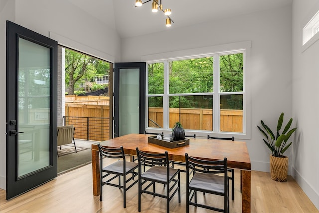 sunroom / solarium featuring lofted ceiling, a chandelier, and a wealth of natural light