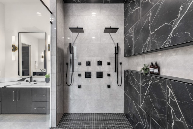 bathroom with a tile shower and vanity