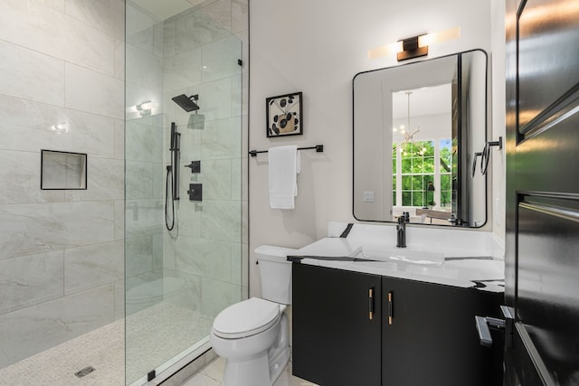 bathroom featuring toilet, tile patterned floors, a notable chandelier, vanity, and tiled shower