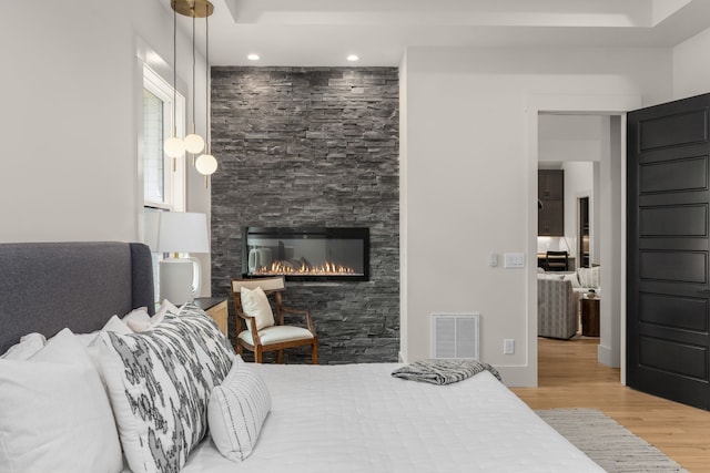 bedroom with a fireplace and hardwood / wood-style flooring