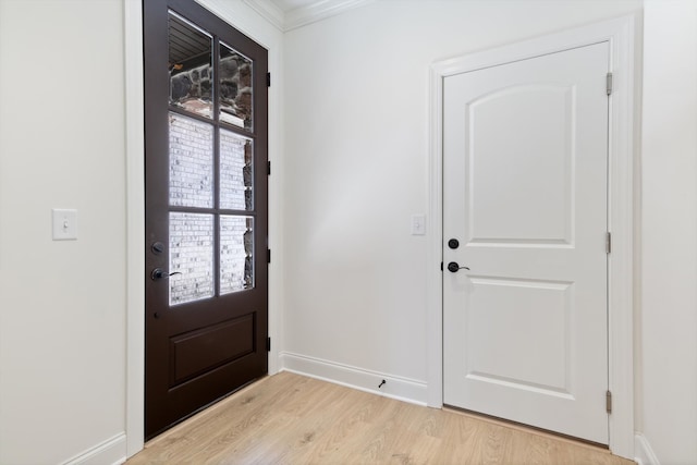 doorway with crown molding and light hardwood / wood-style flooring