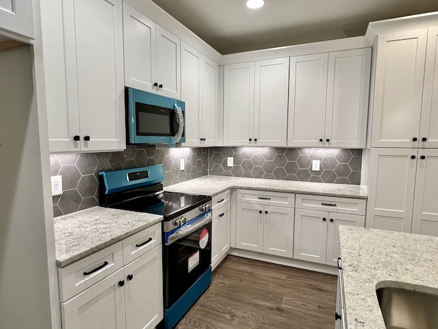 kitchen with light stone counters, dark wood-type flooring, white cabinetry, range with electric cooktop, and backsplash