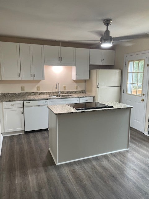 kitchen featuring light stone countertops, dark wood-type flooring, white appliances, sink, and white cabinetry